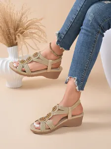 Detailed view of the intricate beaded straps and woven design on these gold wedge sandals.