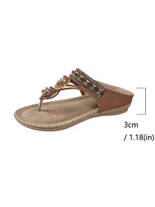 Close-up of brown bohemian thong sandals featuring floral decor and a 3cm wedge heel height