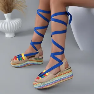 Detail of rainbow woven platform sandals with vibrant blue crisscross leg ties.