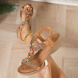 Dettaglio di sandali con zeppa boho con perline colorate e decorazioni in strass