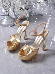Detailed view of golden platform sandals with a wine glass heel and crocodile texture