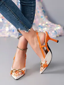 Close-up of elegant orange slingback stilettos with embroidered floral patterns.