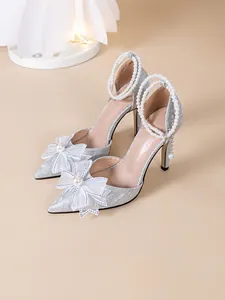 Escarpins argentés à paillettes avec brides de cheville en perles et nœuds blancs élégants
