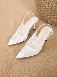 Elegant white lace slingback high heels featuring mesh floral embroidery and a pointed toe