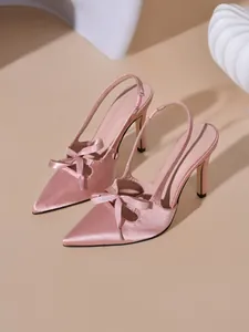 Eleganti décolleté slingback in raso rosa con fiocco sulla punta, stile a spillo.