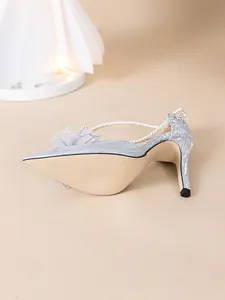 Vue détaillée d'escarpins argentés à paillettes avec bride perle et nœud en mesh