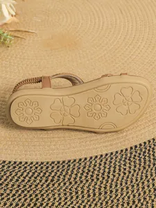 Detailed view of women's flat sandal sole with anti-slip floral patterns