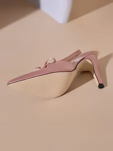 Primo piano di décolleté slingback in raso rosa con fiocco elegante e tacco a spillo.