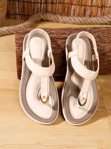 Sandalias planas beige de estilo bohemio con costuras decorativas y hebilla metálica