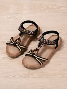 Macro view showing ethnic beaded straps and wooden ring detail of bohemian sandals