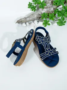 Detailed shot of Bohemian blue flat sandals with intricate rhinestone floral patterns