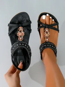 Detail of black bohemian flat sandals with handcrafted beads and soft quilted sole