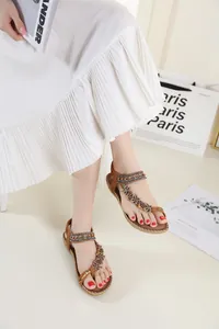 Detail view of bohemian flat sandals with intricate beadwork and butterfly accents.