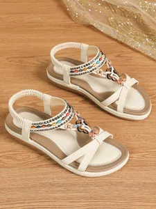 Detailed view of beige Bohemian flat sandals with colorful bead and floral accents