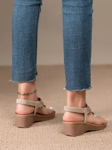 Detailed back view of bohemian wedge sandals featuring beaded straps and elastic heel