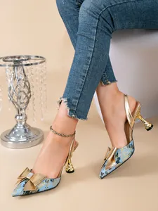 Detail van blauwe bloemen slingback hakken met gouden strass strik en gebeeldhouwde hak