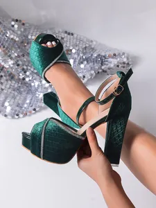 Detail shot of emerald green velvet platform sandals with rhinestones and quilted pattern