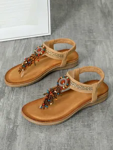 High quality detail of bohemian flat sandals with colorful beadwork and tassel accents