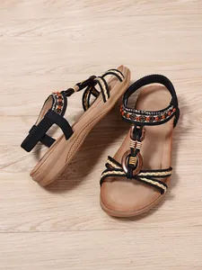 Bohemian flat sandals featuring ethnic beaded straps and decorative wooden ornaments