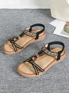 Detailed view of Bohemian flat sandals with wooden buckle and handmade ethnic embroidery