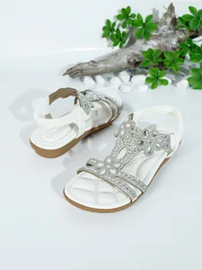 Detailed view of white Bohemian flat sandals with sparkling rhinestone embellishments