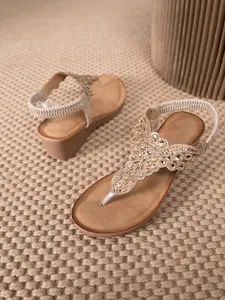 Close-up of bohemian thong sandals with intricate rhinestone beadwork and elastic back strap