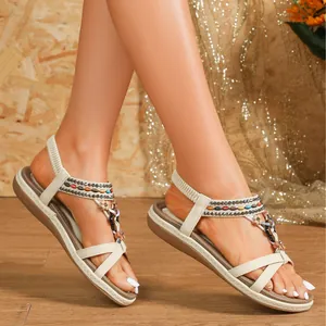 Bohemian flat sandals with criss-cross straps and colorful rhinestone details for beach wear