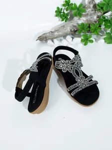 Detailed view of Bohemian flat sandals featuring intricate rhinestone flower patterns.