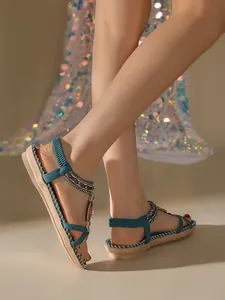 Detailed view of bohemian flat sandals with handmade beads and rhinestones on feet.