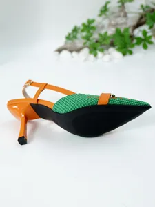 Detail view of orange and green slingback stiletto heels with pattern and buckle