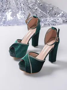 Detailed view of dark green velvet platform sandals with sparkly rhinestone trim