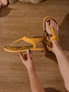 Vista detallada de las sandalias planas amarillas estilo bohemio con suela suave antideslizante.