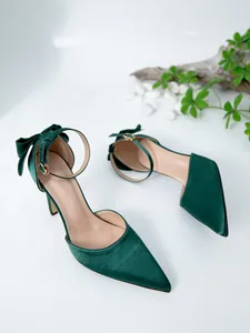 Eleganti décolleté in raso verde scuro a punta con cinturino alla caviglia e fiocco decorativo.