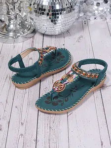 Detail view of teal bohemian flat sandals with colorful beadwork and rhinestones