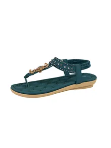 Detailed side view of teal bohemian flat sandal with sparkling rhinestones