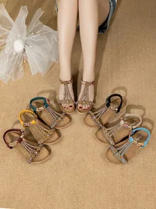 Dettaglio di eleganti sandali bohémien con perline in vari colori e strass luminosi