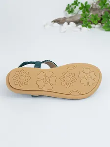 Detail view of Bohemian flat sandal sole with anti-slip floral patterns and green strap