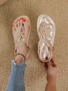 Detailed view of rose gold bohemian flat sandals with rhinestones and shell pattern