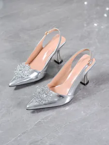 Close-up of elegant silver slingback heels with sparkling rhinestone flower cluster