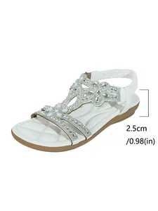 Close-up detail of white Bohemian flat sandal with rhinestone flowers and 2.5cm heel