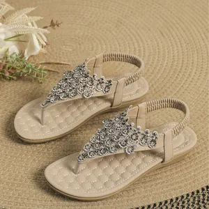 Elegant beige flat thong sandals with intricate rhinestone beading and soft quilted sole