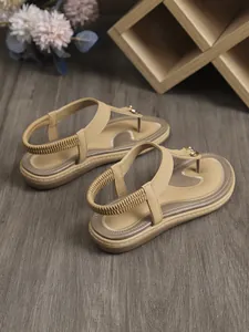 Vista detallada de las sandalias planas beige de estilo bohemio con tira en talón
