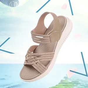 Primo piano di sandali bohémien con cinturini intrecciati elastici e suole spesse.