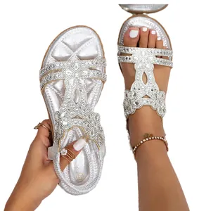 Macro view of silver Bohemian flat sandals decorated with intricate rhinestones.