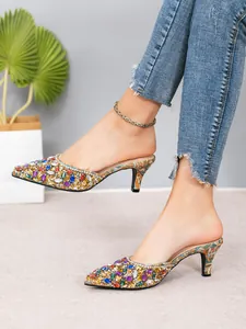 Close-up of elegant pointed-toe mules with colorful rhinestones and 7cm heels