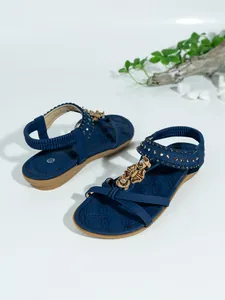 Detalle de sandalias planas azules bohemias con cuentas florales y tira elástica
