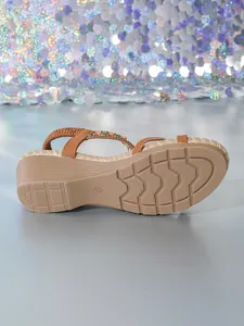 Detailansicht von Bohemian-Keilsandalen mit Holzperlen und Strass-Riemchen.