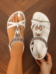 Detailansicht der handgefertigten flachen Boho-Sandalen mit Holzperlen und glänzenden Strass
