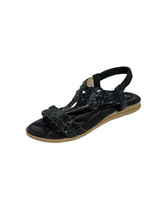 Detailed view of black bohemian flat sandals with sparkling rhinestone embellishments