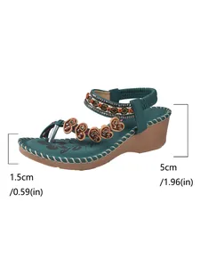 Ethnic teal Bohemian wedge sandal featuring beaded heart charms and 5cm heel height detail